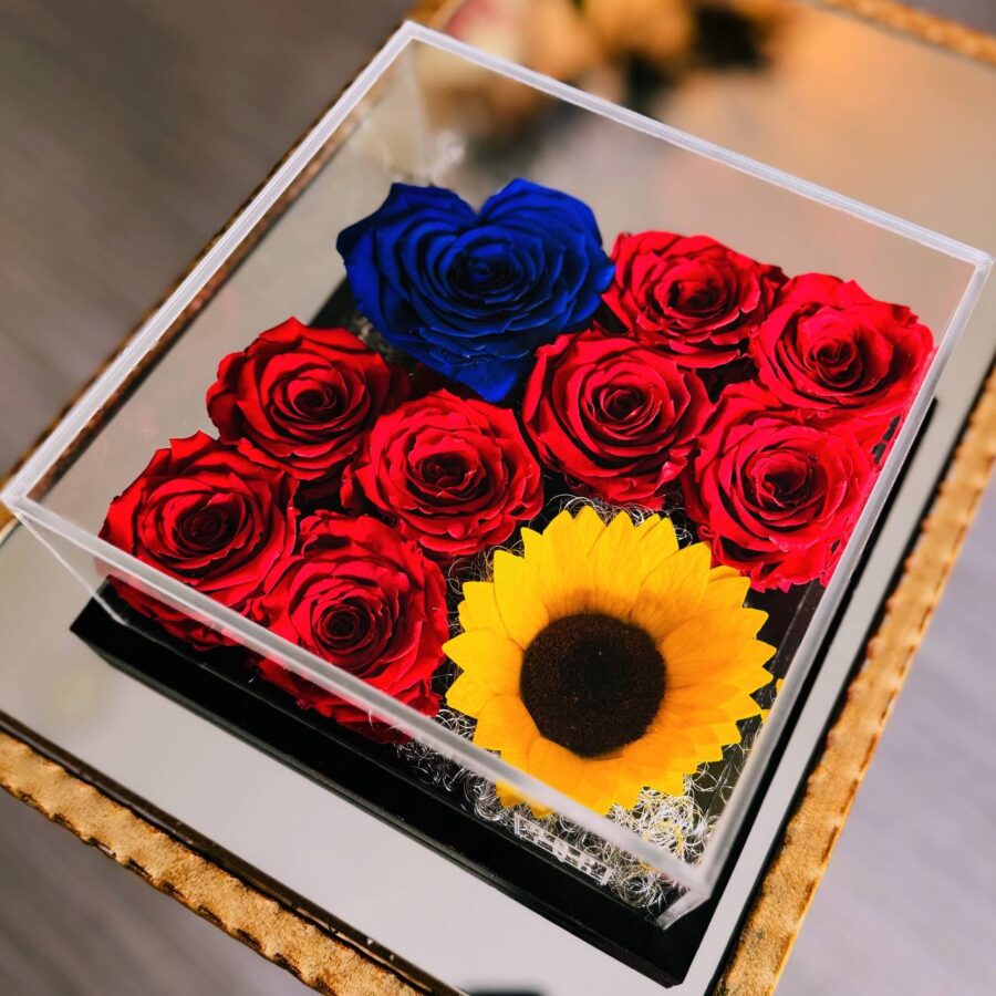infinity flowerbox in plexiglass con otto rose rosse stabilizzate e un girasole gigante stabilizzato e una rosa a forma di cuore stabilizzata